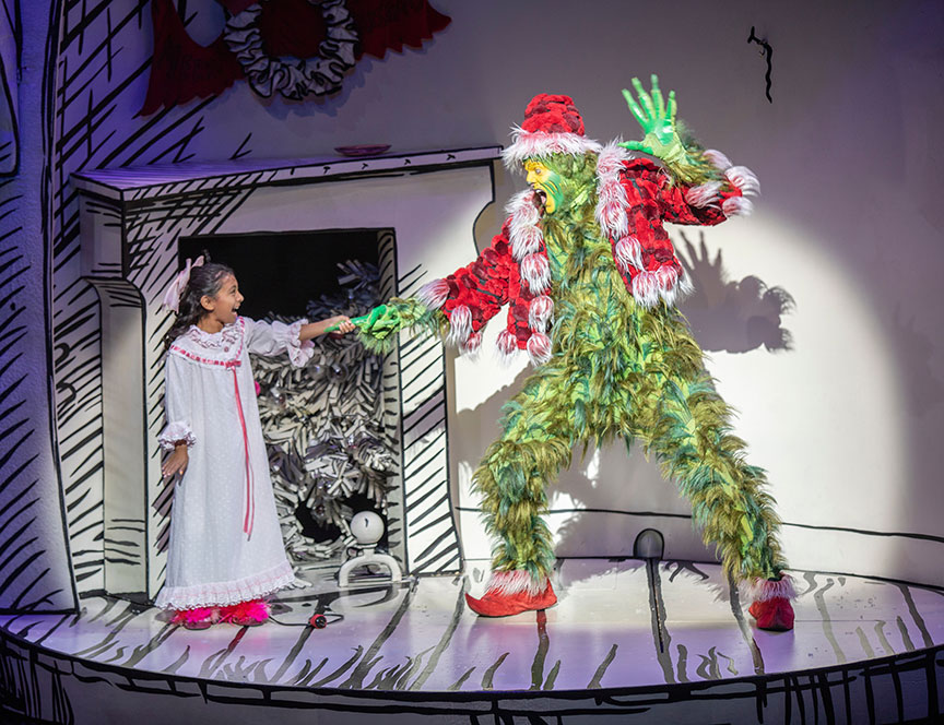 Leila Manuel as Cindy-Lou Who and Edward Watts as The Grinch. Dr. Seuss's How the Grinch Stole Christmas!, book and lyrics by Timothy Mason, music by Mel Marvin, original production conceived and directed by Jack O'Brien, original choreography by John DeLuca, and directed by James Vásquez, running November 10 – December 29, 2019 at The Old Globe. Photo by Jim Cox.